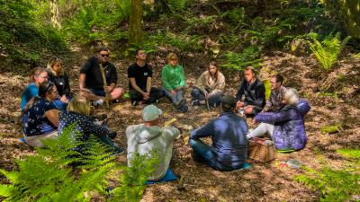 Group of adults sitting together in a circle in nature
